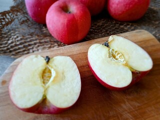sliced red apple on wooden board