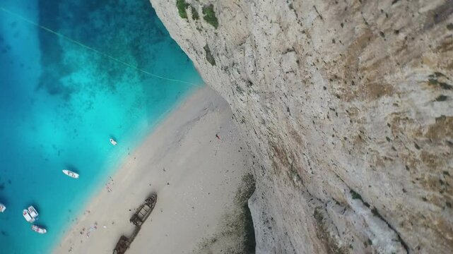 Cinematic spinning shot down on bungee jumping man off Greece cliff