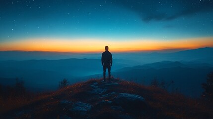 Obraz premium Man Standing on Mountain Under Dark Blue Sky