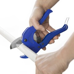 Worker cuts off a blue pvc pipe with blue pvc cutter on white background.