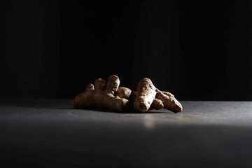 fresh turmeric root isolated on dark background, turmeric (Curcuma longa Linn), spice concept