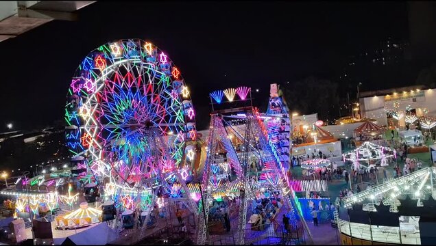 Closeup of multi-coloured Giant Wheel during Dussehra Mela in Delhi, India. Bottom view of Giant Wheel swing. Ferris wheel with colourful cabins during evening time.