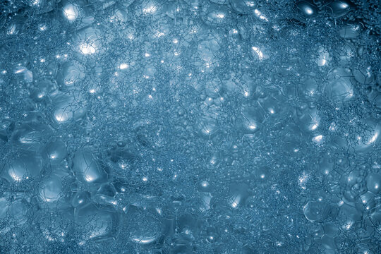 A close-up view reveals a multitude of blue bubbles clustered together, reflecting diffused light, creating a captivating texture and pattern in this abstract display.