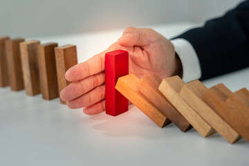insurance with hands protect domino. Businessman hands stop dominoes falling in business crisis....