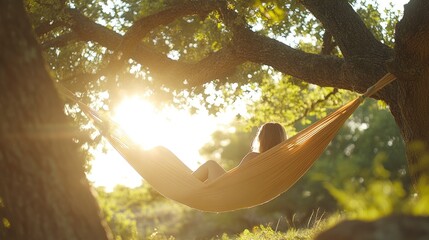 A woman relaxing in a hammock, bathed in warm sunlight.