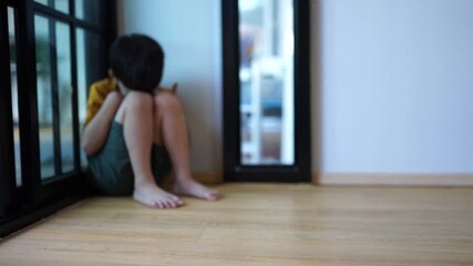 A sad young boy sat in the corner crying and covering her face with her hands. The concept of child abuse in the family Parents punish their children into a corner, the child is depressed, crying, lif