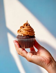 Mano sosteniendo cupcake de dulce de leche