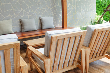 Wicker chair and wooden table in restaurant,Rattan chair in scandinavian interior of living room,Mediterranean minimal wall and green plant exterior architecturer,warm beige tones,copy space.