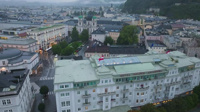 Aerial view of Salzburg historic city center with its traditional buildings, Dreifaltigkeitskirche, and the Salzach River flowing through