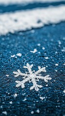 Obraz premium A close-up of a snowflake on a blue surface, highlighting winter's beauty.