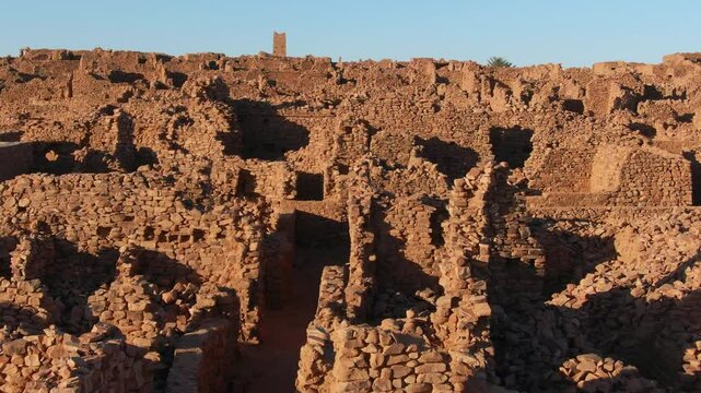 Drone flying over ruins of ancient and historic city of Ouadane, Mauritania in Africa. Aerial forward ascending