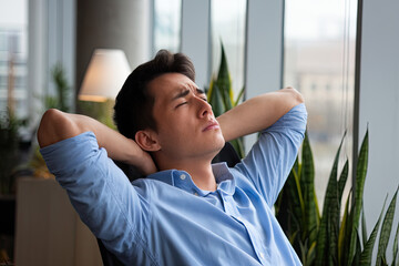 An employee taking a short break, leaning back in their chair with an exhausted expression