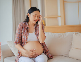 asian pregnant woman sitting on sofa
