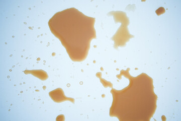 A drink was accidentally spilled on a desk with a laptop and glasses, creating a mess