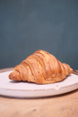 A Freshly Baked Croissant Placed Beautifully on a Plate Ready to Enjoy With Your Meal