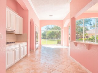 Fototapeta premium Bright, airy interior with pink walls and large windows showcasing greenery.