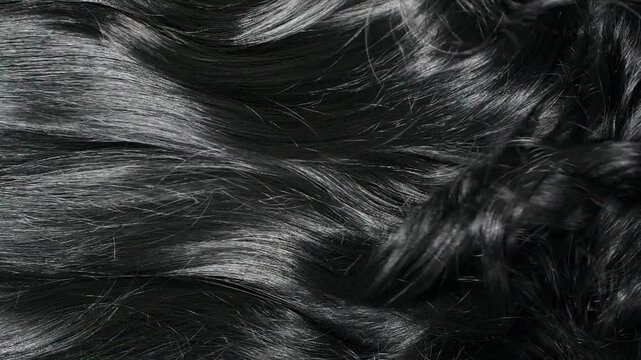 Closeup beautiful female black long curly hair texture background in slow motion
