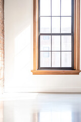Fototapeta premium Bright and airy interior space featuring a large window with wooden trim in natural light