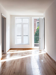 Fototapeta premium Bright, minimalistic room with large windows showcasing natural light in an urban setting