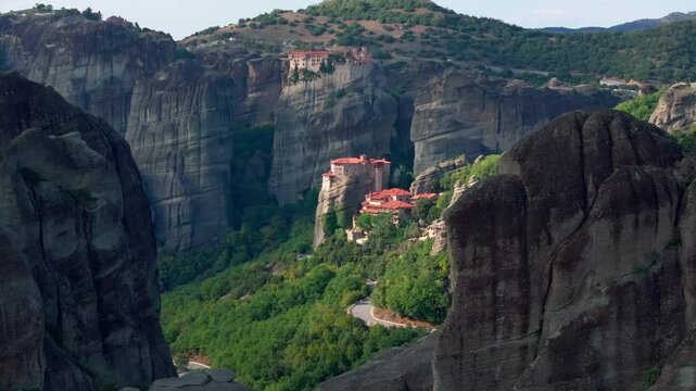 Aerial views reveal a monastery nestled among the striking rock formations of Meteora, Greece, showcasing the area's stunning landscape and rich cultural heritage