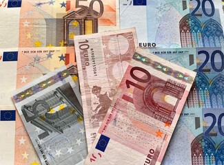 Close-up of euro paper banknotes. Euro bills of different denominations are scattered on the table....