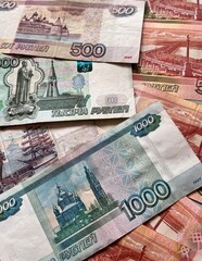 Close-up of Russian rubles. Ruble banknotes of different denominations are scattered on the table. Money financial background. Flat lay, close-up, top view