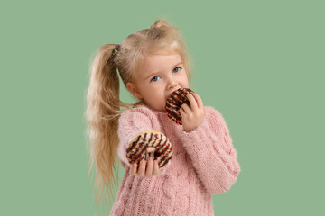 Cute little girl with donuts on green background