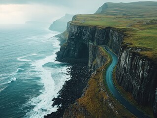 Breathtaking aerial view of a winding cliffside road along rugged coastline with ocean waves below