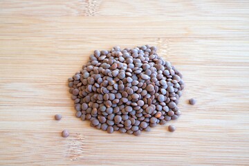 legumes. pile of lentils on a wooden surface.