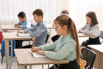 Group of children doing exercises during lesson in classroom