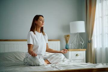 Young woman with eyes closed doing Yoga breathing exercise in  morning.