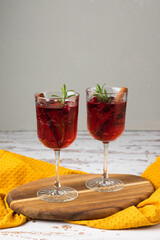 Autumn spiced cocktail with wine on a rustic holiday table. Homemade seasonal drink Sangria for Halloween, Thanksgiving with cinnamon and rosemary. Decorative textile pumpkins and candles