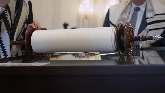 A crafted Torah scroll is showcased during a religious ceremony, highlighting its cultural importance