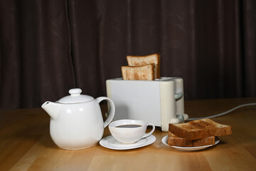 Close-up of white toaster with bread slices and drinks on table