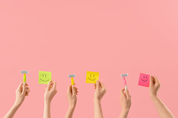 Female hands with sticky notes and razors on pink background