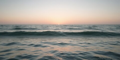 Obraz premium Panorama of gentle sea waves illuminated by the soft light of dawn, beach