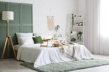Interior of bedroom with breakfast and books on bed