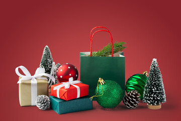 Christmas gift box and present with green christmas ball and decor on red background