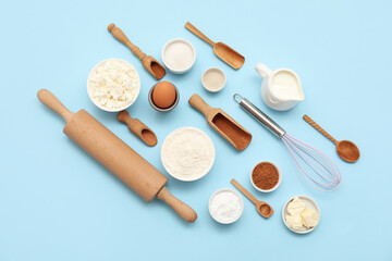 Different ingredients for preparing sweet cinnamon roll on blue background