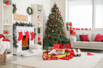 Interior of living room with Christmas tree, fireplace and open suitcase