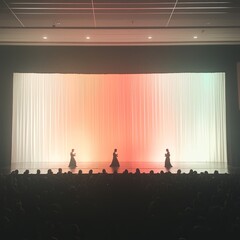 Dancers performing on stage with colorful backdrop in front of an audience.