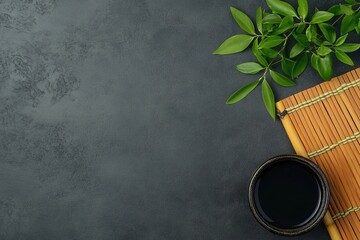 Tea ceremony setup with bamboo mat and green leaves.