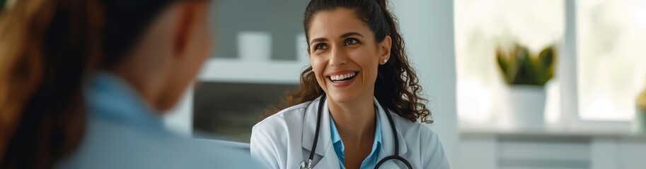 A female doctor is smiling while talking to a patient in a medical office. They engage in a friendly and reassuring conversation as part of the healthcare providers medical assistance and support