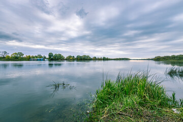 A body of water with a boat in the foreground and a cloudy sky in the background