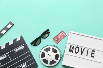 Movie clapper with word MOVIE, cinema ticket, glasses and film reel on turquoise background
