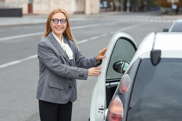 Mature businesswoman near car on city street