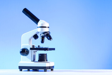 Modern microscope on blue background