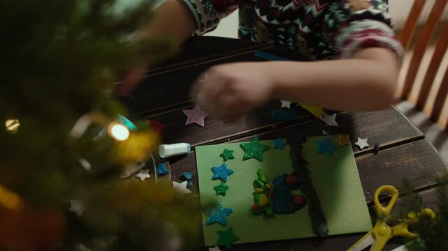 Christmas crafts. Child makes DIY Christmas holiday cards