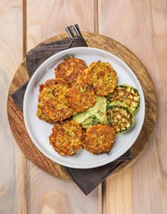 Delicious sweet potato and zucchini rosti with guacamole on white plate