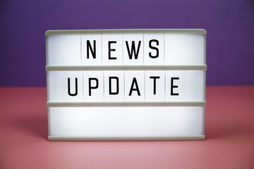 News Update letterboard text on LED Lightbox on pink and purple background